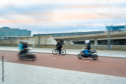 Moving bicyclist and motorcyclist on a blurry background