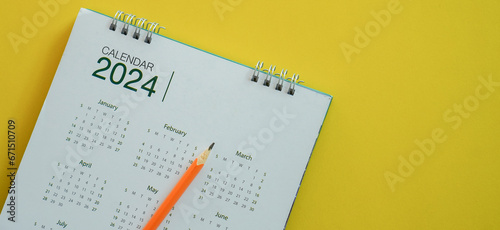 close up top view on white calendar 2024 with schedule of month and pencil to write or note and mark on important date for lifestyle and new year resolution concept photo