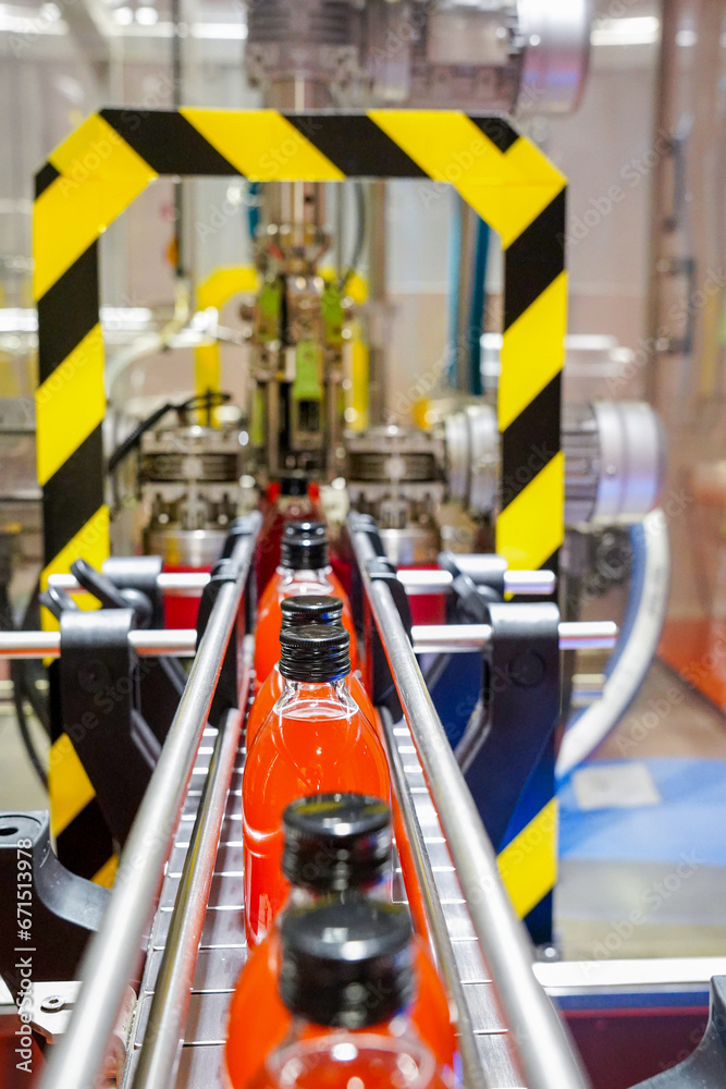 Fototapeta premium automation of manufacturing, bottling and labeling process of a red drink in an industrial factory