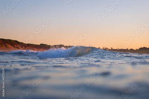 A small barrel wave in the ocean shore.