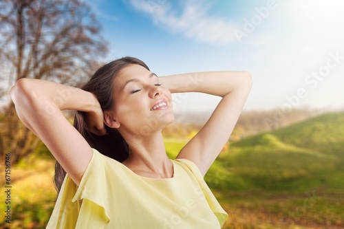 Young happy woman outstretched arms and breathing fresh air