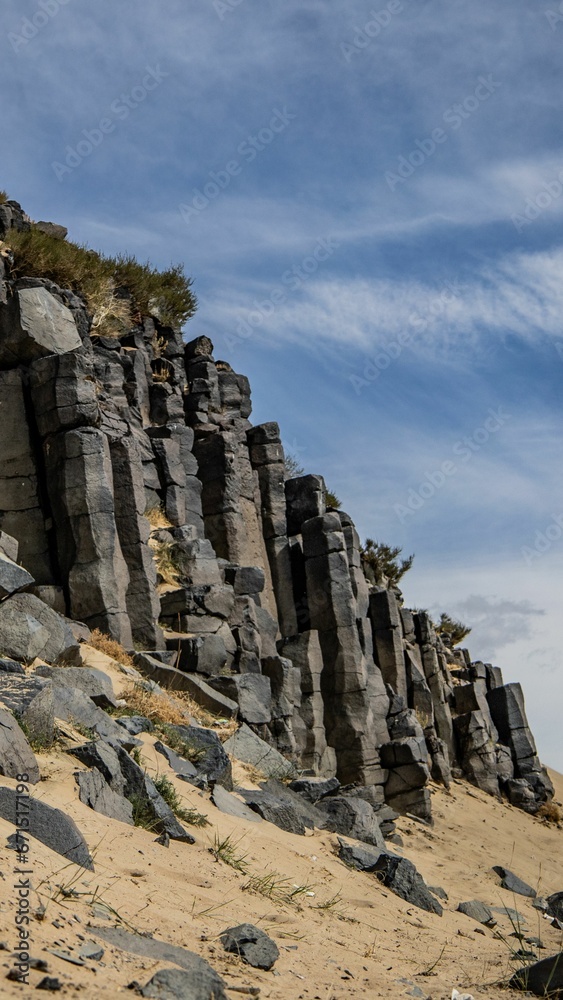 Vertical of a rocky shore under a blue sky Vertical of a rocky shore under a blue sky