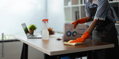 Asian woman cleaning in work room at home. Young woman housekeeper cleaner use a cloth to wipe equipment for working. concept housekeeping housework cleaning photo
