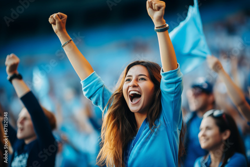 woman and fans screaming supporting team in stadium wearing blue with cyan flag