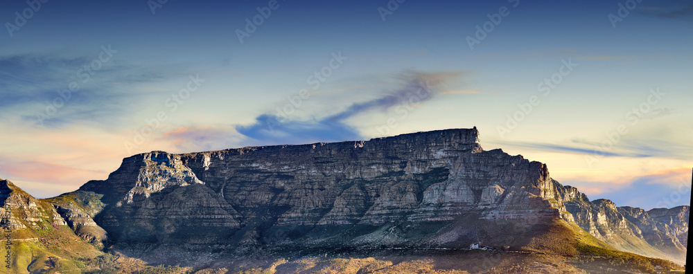 Naklejka premium Copy space with scenic landscape of Table Mountain in Cape Town with cloudy blue sky background. Steep rocky mountainside with green valley. Breathtaking and magnificent views of the beauty in nature