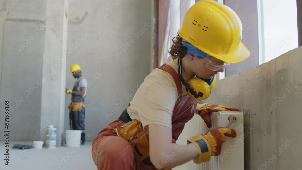 custom made wallpaper toronto digitalWoman screwing tap on heater at construction site with co-worker