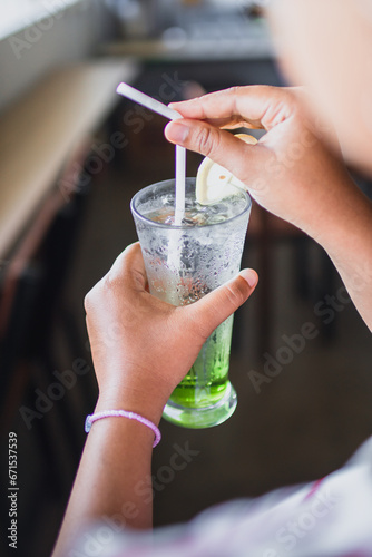 Freshly squeezed sweetened lemonade on ice on women hand