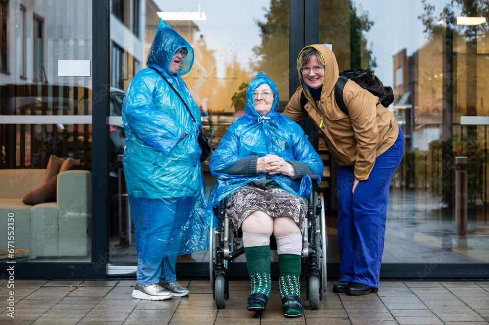 Family portrait of a 41 yo woman with Down Syndrome, a grandmother in a wheelchair and a 37 yo woman wearing rain clothes, Belgium