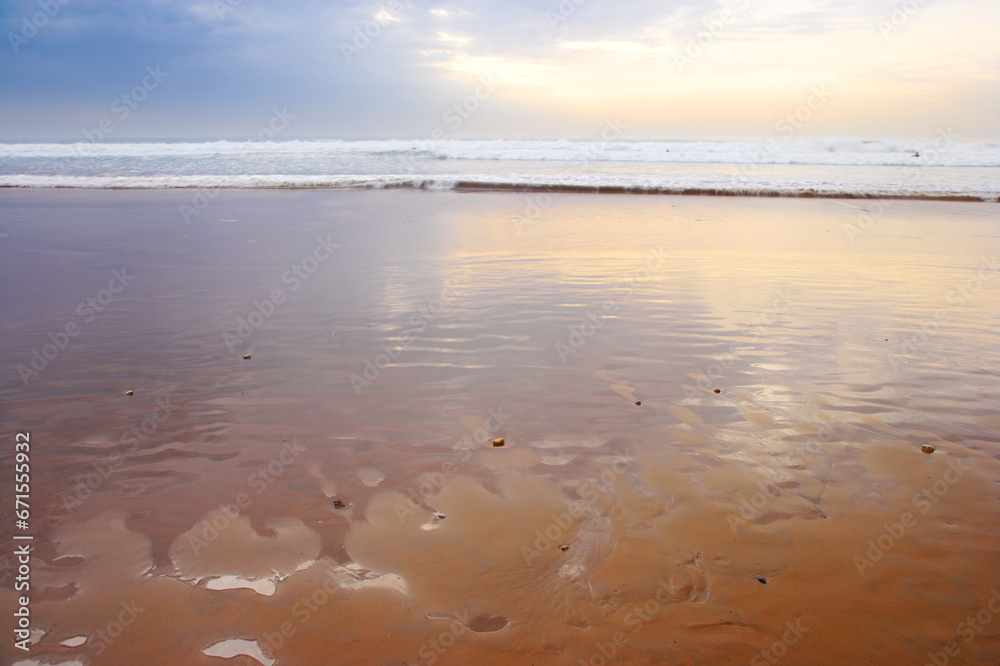Obraz premium Seascape and landscape of a golden sunset on the west coast of Jutland in Loekken, Denmark. Beautiful cloudscape on an empty beach at dusk. Clouds over the ocean and sea in the evening with copyspace