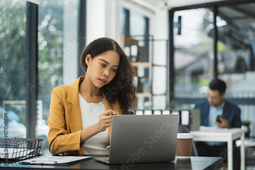 Businesswomen hand working with tablet and laptop computer with documents on office desk in modern office.
