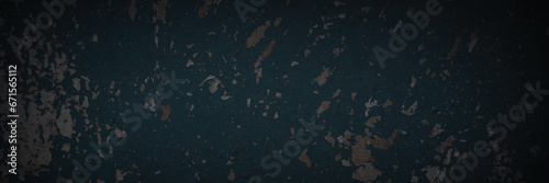 Dark wide panoramic background. Peeling paint on a concrete wall. Dark grunge texture of old cracked flaking paint. Weathered rough painted surface. Patterns of cracks. Darkness background for design. photo