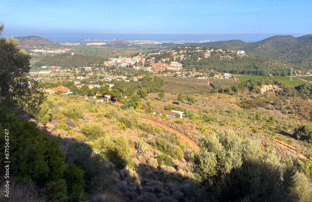 Houses at Gilet Town in mountains. Urbanization with houses and homes in mountains hills. View on city from mountain. Rural landscape with hills. Spain mountains landscape in Sierra Calderona park.