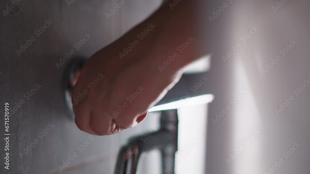 Lady turns on hot water in modern shower. Hand with manicure of woman unscrews tap to wash in modern shower. Female going to washing turns on tap Lady turns on hot water in modern shower. Hand with manicure of woman unscrews tap to wash in modern shower. Female going to washing turns on tap