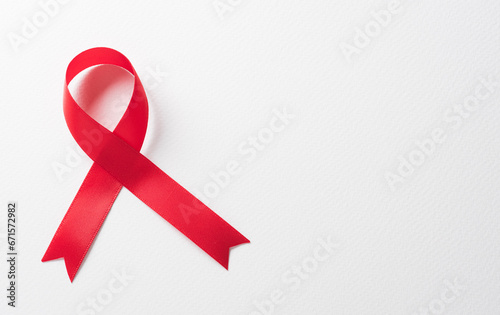 Closeup red ribbon HIV, world AIDS day awareness ribbon on white background. Healthcare and medicine concept.