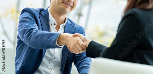 笑顔で握手をする男女のビジネスマン