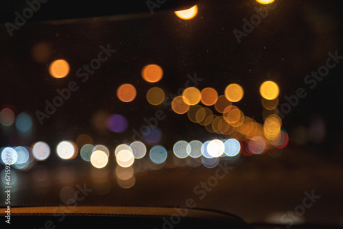 Car windshield view on New York night highway with cars and street lamps. Abstract stylish urban backgrounds. Defocused lights city, style color tone, design concept. Copy ad text space, wallpaper