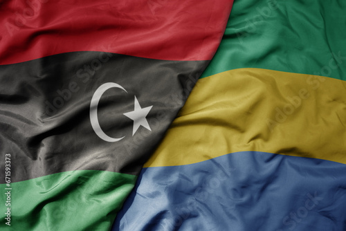 big waving national colorful flag of libya and national flag of gabon