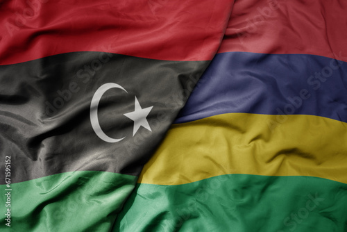 big waving national colorful flag of libya and national flag of mauritius .