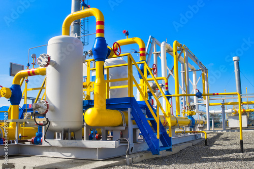 Gas distribution station. Industrial facility. Gas processing station with yellow pipes on a summer day in an open space. Gas supply. Transportation of natural gas through pipes. Background.