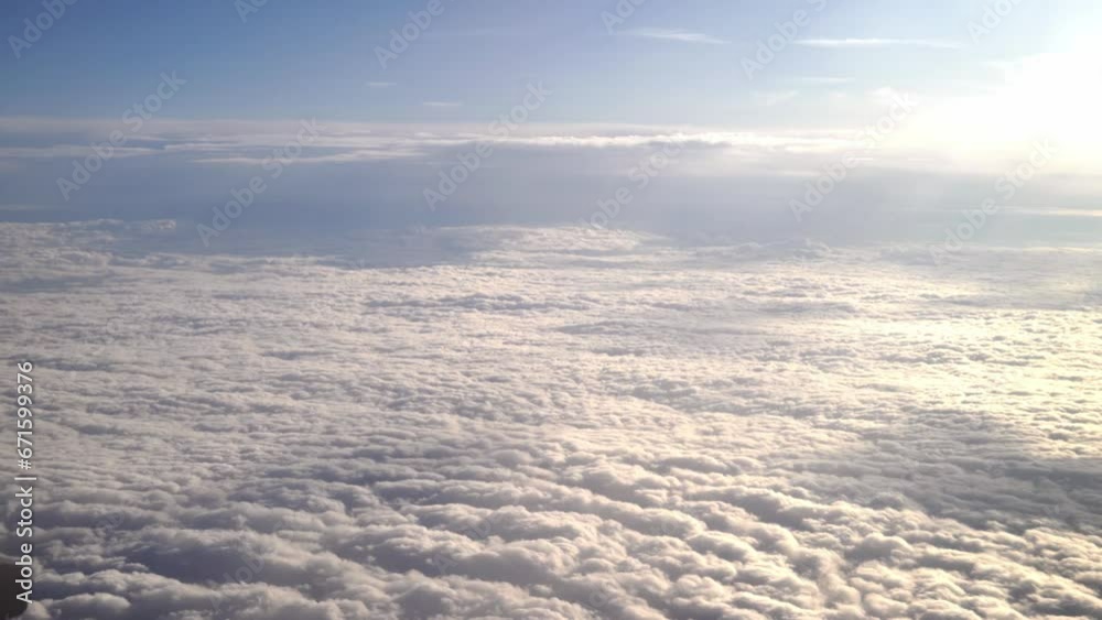 Airplane wing flying above the clouds view from the window of the plane