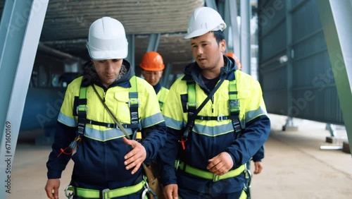 Team of industrial contractors builder metalworker walking at refinery workshop discuss job