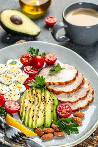 Delicious breakfast avocado, eggs, chicken fillet and cherry tomatoes. Keto diet concept. vertical image. top view
