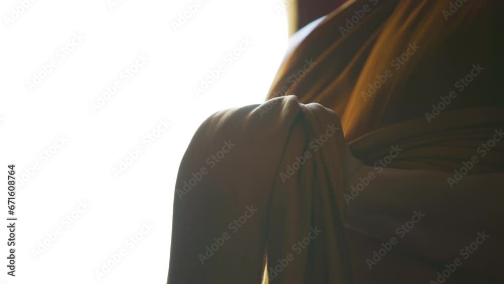 monk uses his hands to hold his robes to get dressed monk uses his hands to hold his robes to get dressed