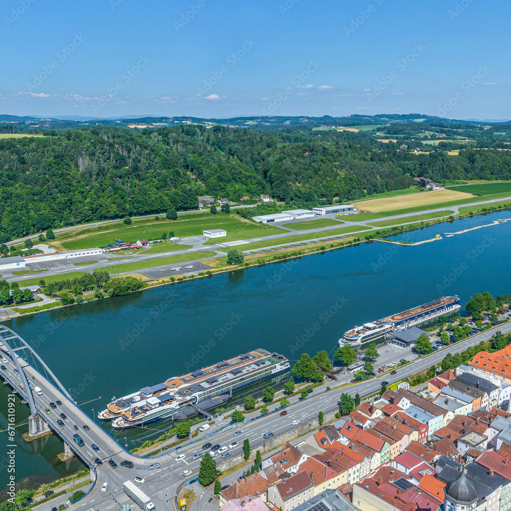 Blick auf das nördliche Donau-Ufer bei Vilshofen in Niederbayern, Donau-Promenade, Flusskreuzfahrtschiffe am Anleger und Flugplatz