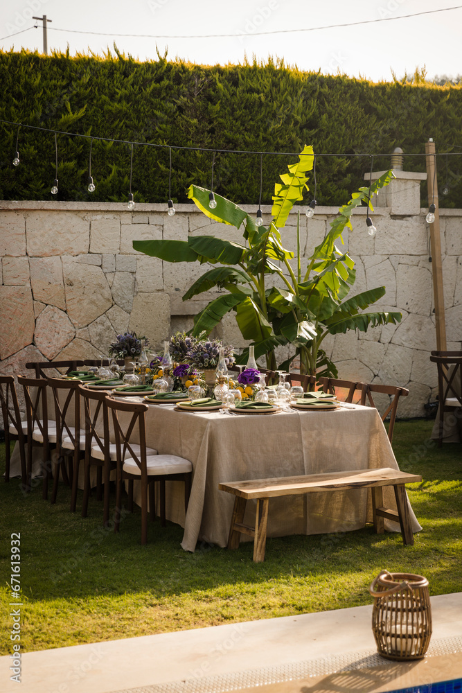 Elegant garden party with a long wooden dining table and lush greenery