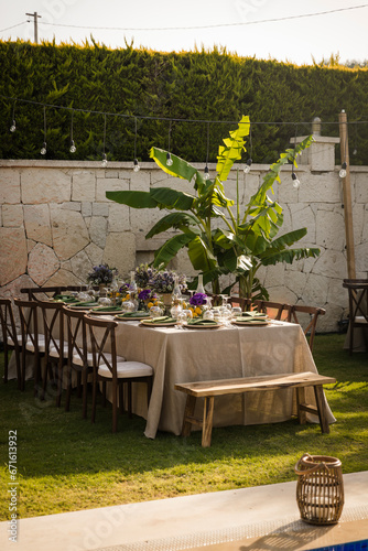 Elegant garden party with a long wooden dining table and lush greenery
