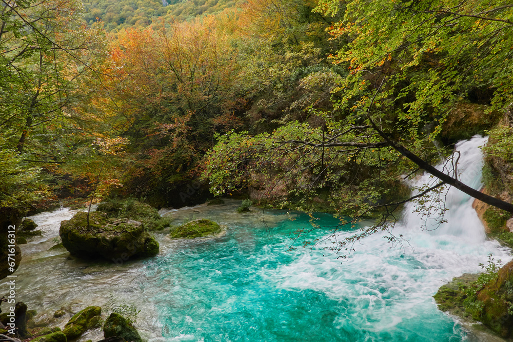 The waterfalls and crystal clear, blue, turquoise and green waters of the Nacedero del Urederra, with its beech forest with its autumn colors in the Sierra de Urbasa-Andía. Navarre. Spain