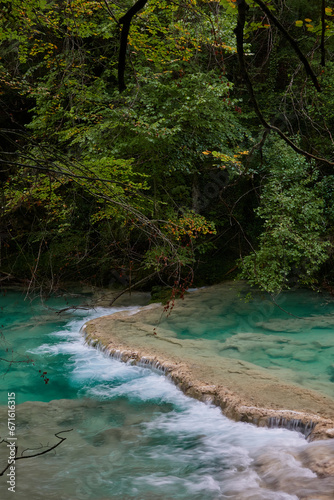 The waterfalls and crystal clear, blue, turquoise and green waters of the Nacedero del Urederra, with its beech forest with its autumn colors in the Sierra de Urbasa-Andía. Navarre. Spain