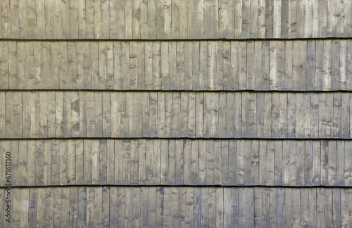 Gray wooden roof tiles background texture. A close up of old gray roof covered with wooden tiles.
