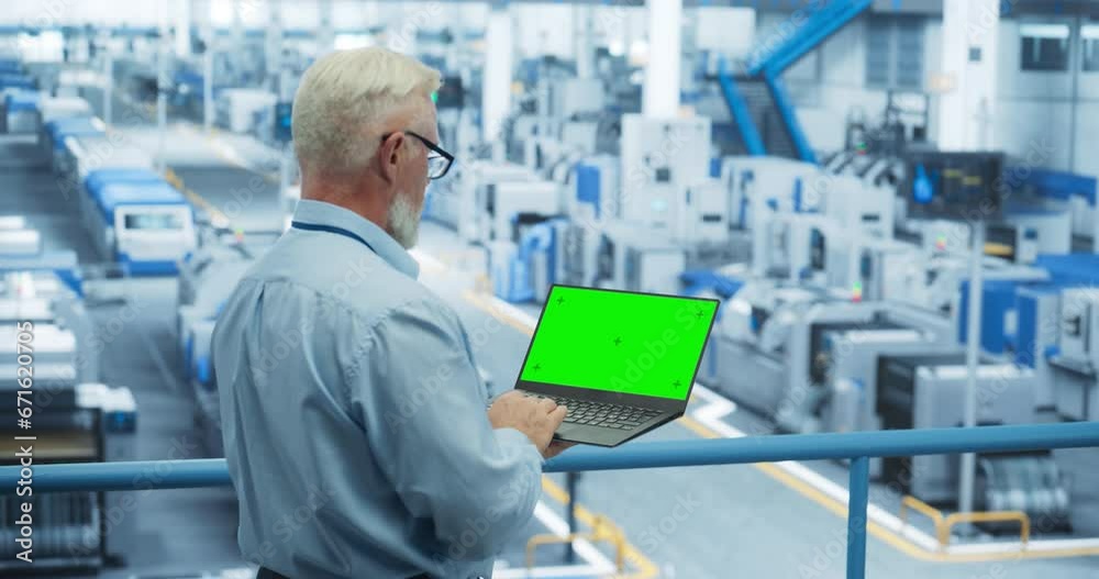 Electronics Manufacturing Project Manager Working on Laptop Computer with Green Screen Template at a Factory. Middle Aged Specialist Developing, Maintaining, Upgrading Programs for Machine Production
