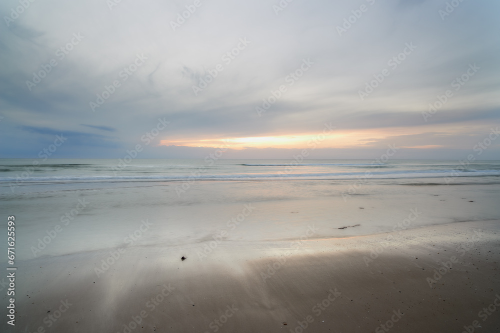 Seascape and landscape of a blue sunset on the west coast of Jutland in Loekken, Denmark. Beautiful cloudscape on an empty beach at dusk. Clouds over the ocean and sea in the evening with copyspace