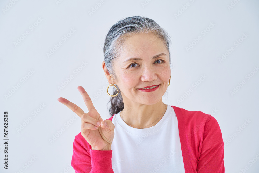 ピースサインをするシニア女性 ピースサインをするシニア女性