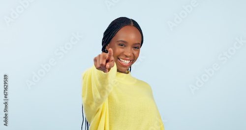 Pointing to you, motivation and black woman with opportunity, choice and announcement on a blue studio background. African person, model or girl with hand gesture, mockup space and feedback with news