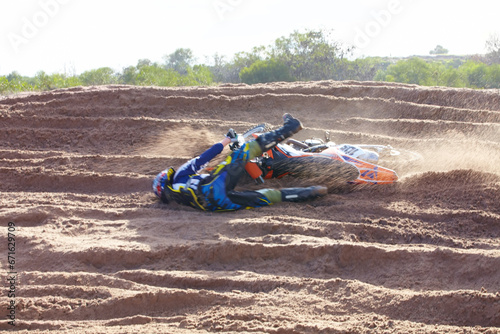 Sand, accident and motorbike for sports with action for challenge or competition with power. Speed, mistake and desert with bike for race or adventure in outdoor with freedom or fearless driving.