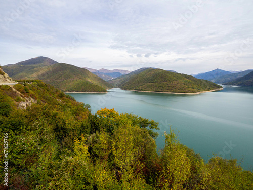 The one part of curved road with beautiful mountain, clear sky and blue water in Zhinvali reservoir, Georgia.