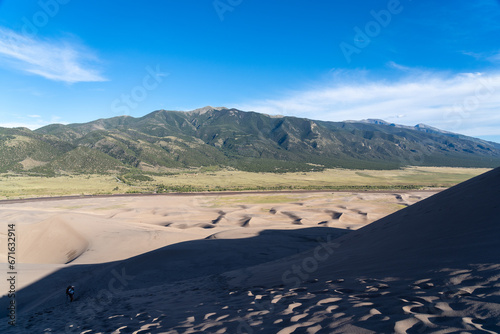 View from the top at golden hour at Great Sand Dunes National Park in Colorado on a sunny summer evening  with mountains in the background