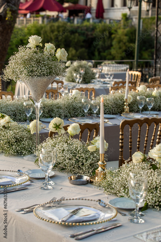A luxurious, elegantly decorated wedding venue with a sea-view outdoor area. The decoration of the wedding venue features cream colors and tones, creating a very charming atmosphere with flowers.