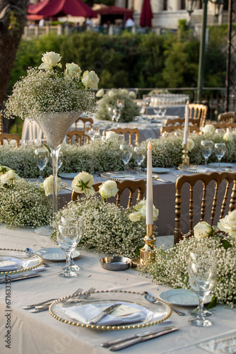 Obraz na płótnie A luxurious, elegantly decorated wedding venue with a sea-view outdoor area. The decoration of the wedding venue features cream colors and tones, creating a very charming atmosphere with flowers. w salonie