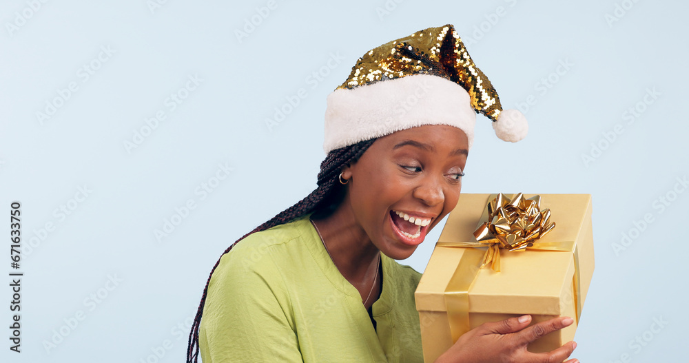 Excited black woman, box and Christmas surprise for gift, present or prize against a studio background. Face of happy and surprised African female person holding ribbon package, parcel or gifts Excited black woman, box and Christmas surprise for gift, present or prize against a studio background. Face of happy and surprised African female person holding ribbon package, parcel or gifts