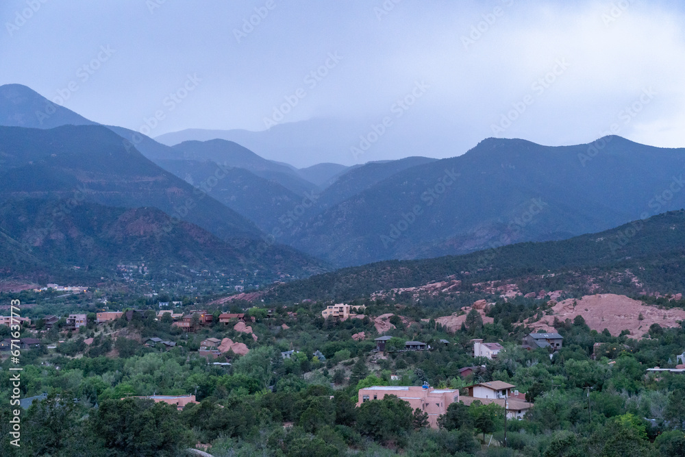 A view of a rainstorm over Pike's Peak and other blue misty mountains on a cloudy summer evening, as viewed from Garden of the Gods in Colorado Springs, CO A view of a rainstorm over Pike's Peak and other blue misty mountains on a cloudy summer evening, as viewed from Garden of the Gods in Colorado Springs, CO