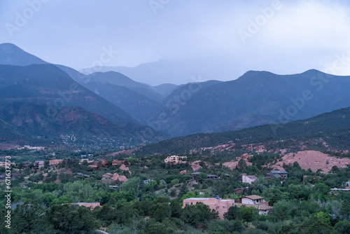 A view of a rainstorm over Pike s Peak and other blue misty mountains on a cloudy summer evening  as viewed from Garden of the Gods in Colorado Springs  CO