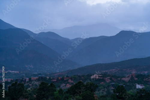 A view of a rainstorm over Pike's Peak and other blue misty mountains on a cloudy summer evening, as viewed from Garden of the Gods in Colorado Springs, CO © Sitting Bear Media