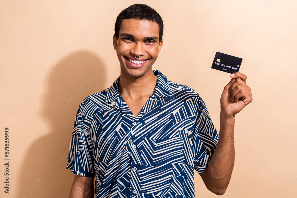 Photo of satisfied cheerful man wear stylish outfit arm demonstrate plastic bank card isolated on beige color background Photo of satisfied cheerful man wear stylish outfit arm demonstrate plastic bank card isolated on beige color background