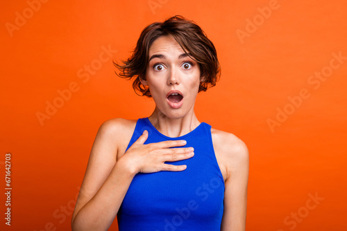 Photo of funky shocked lady wear blue singlet open mouth arm chest isolated orange color background