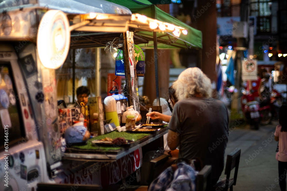 Obraz premium MAE HONG SON, THAILAND - October 30, 2023: Night Market in Pai, nothern Thailand. Pai walking street market, is a food and craft market that operates every night.