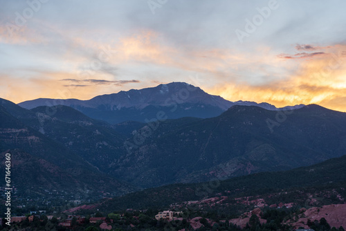 A colorful sunset over Pike's Peak and other blue mountains and red rocks on a fall/summer evening, as viewed from Garden of the Gods in Colorado Springs, CO